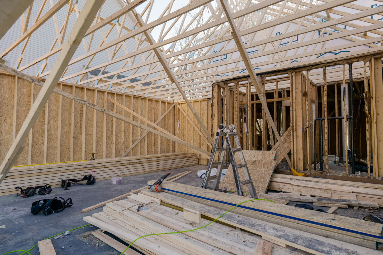 The construction site on Dublin Road showcases wooden framing for a house, with a ladder, tools, and scattered lumber under the partially constructed roof, hinting at an ambitious kitchen remodel.