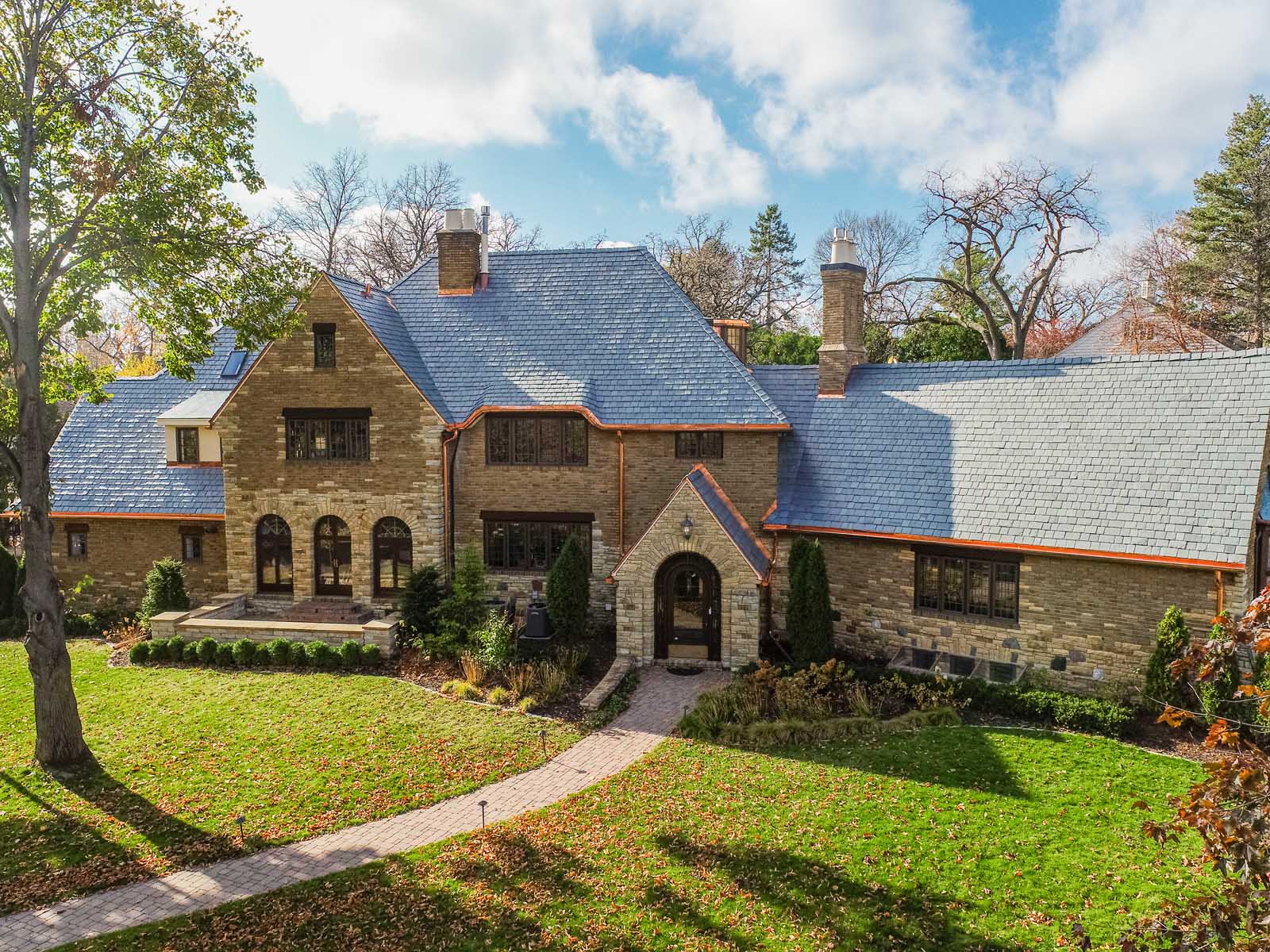 A large stone house with a blue slate roof and arched windows sits along Dublin Road. The landscaped front yard, with its brick pathway, invites you in on a sunny day, hinting at the recent kitchen remodel that makes this home truly exceptional.